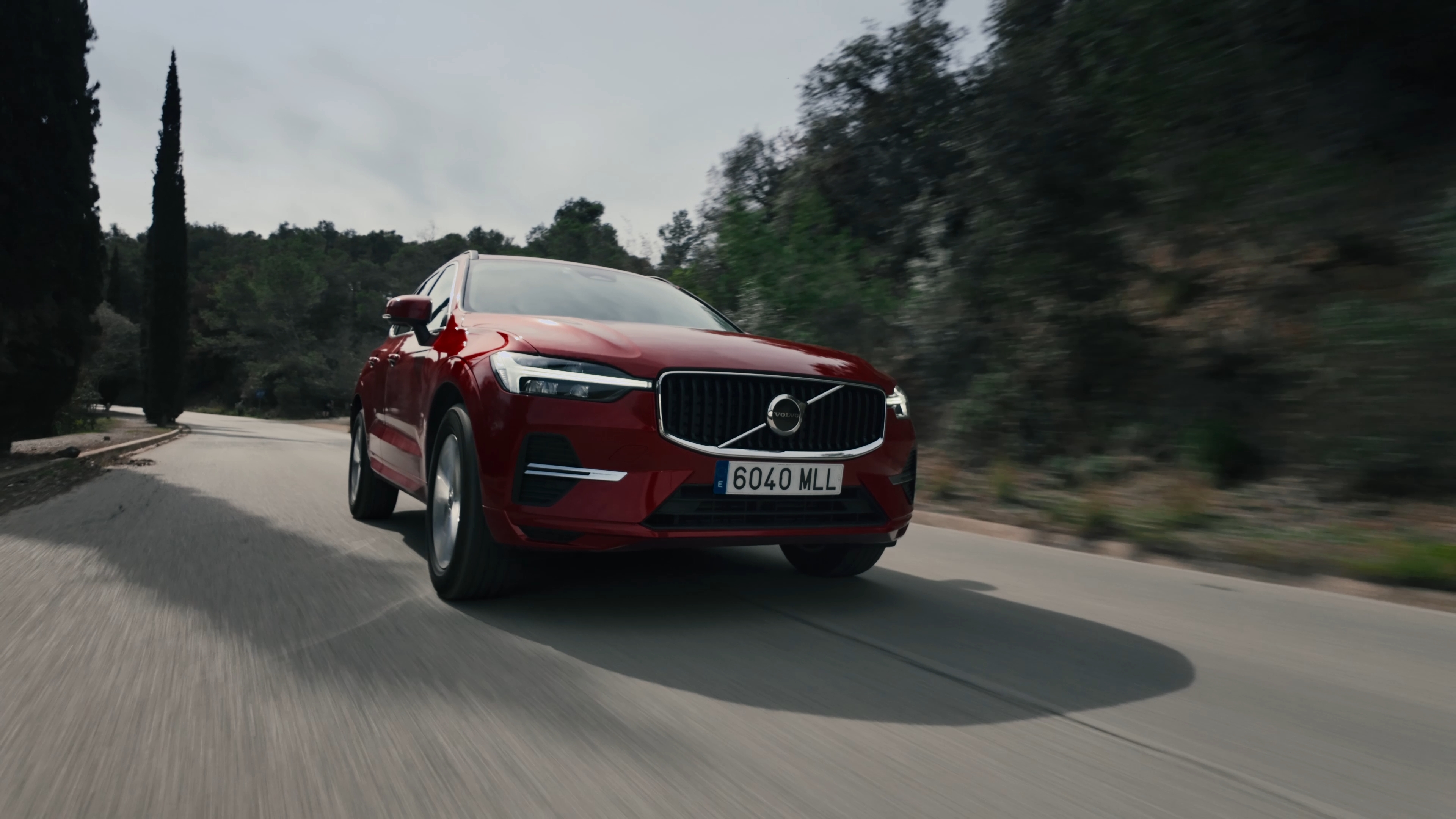 Volvo rojo circulando por una carretera